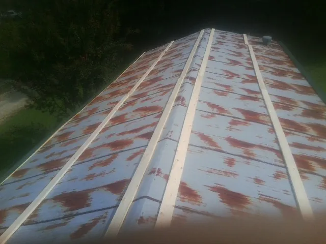 Rusted metal roof panels with new wood purlins before replacement — Storm Damage Roof Repair in Little River Academy by Roofing Brothers