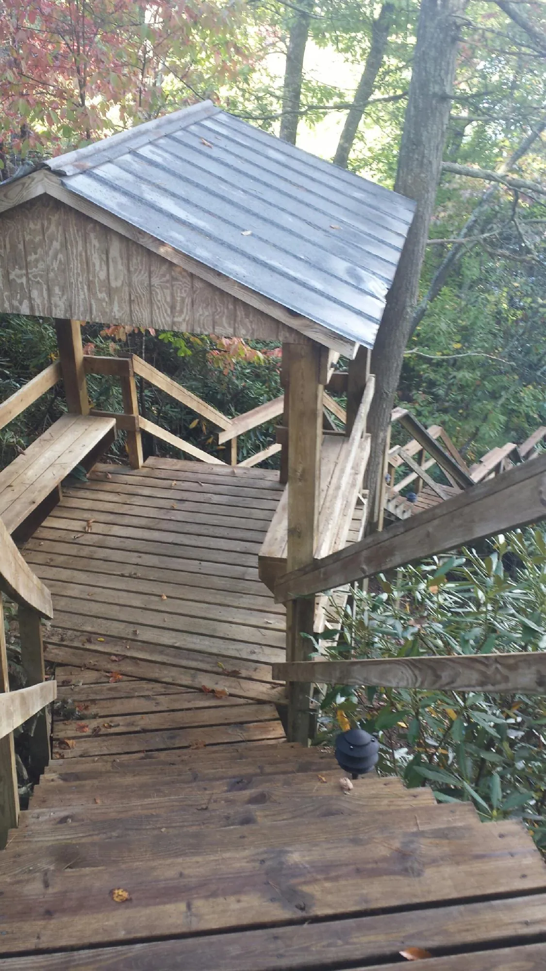 Metal roofed shelter over wooden steps on a wooded walkway — Skylight Repair & Installation work by our crew in Little River Academy