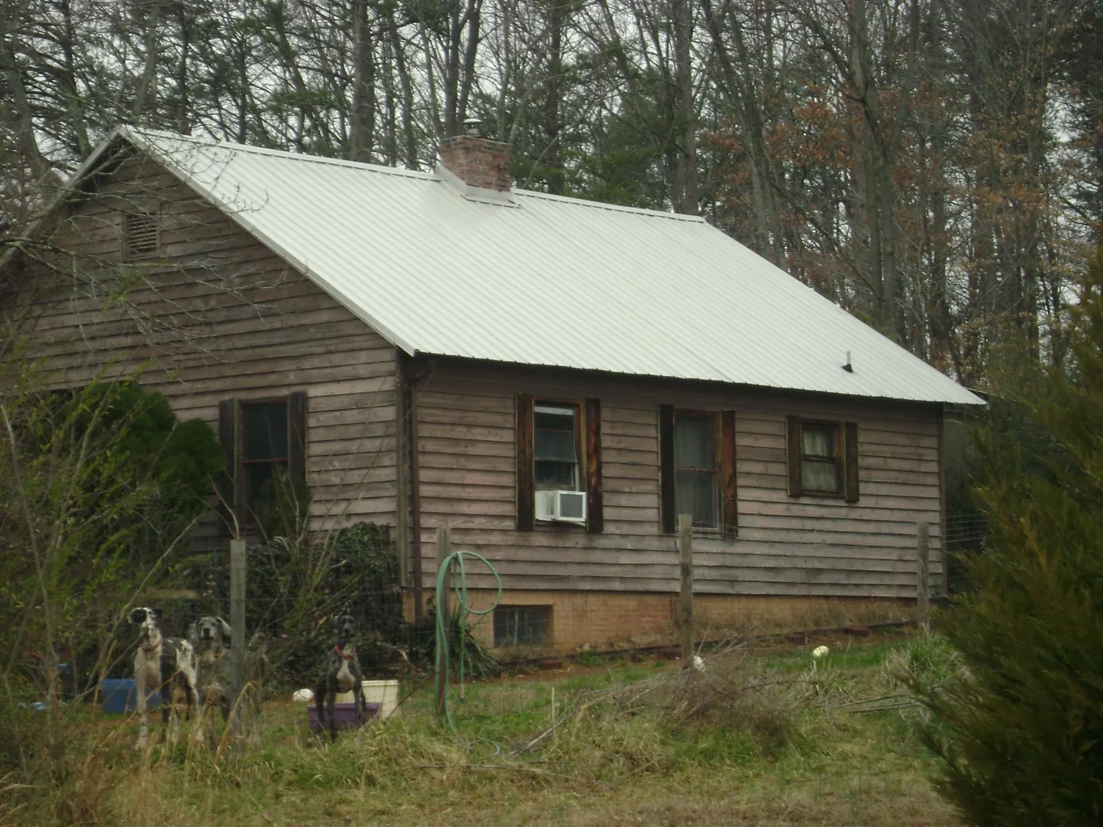White metal roof on an old wood sided farmhouse, from a Metal Roof Installation job in Little River Academy